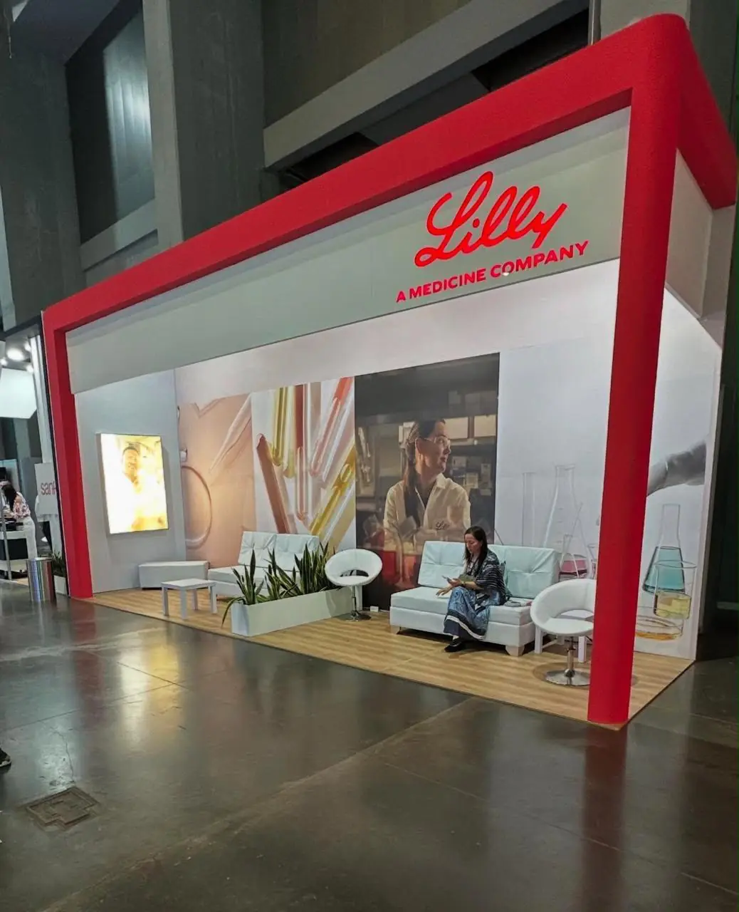 Stand de feria con marco rojo, aviso luminoso, sala de espera y gráfica de gran formato