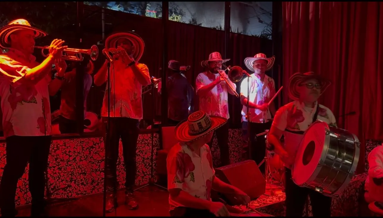Músicos con sombrero vueltiao tocando trompeta y bombo en vivo durante un evento