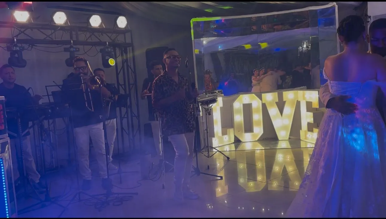 Orquesta tocando en vivo en una boda junto a letras luminosas LOVE
